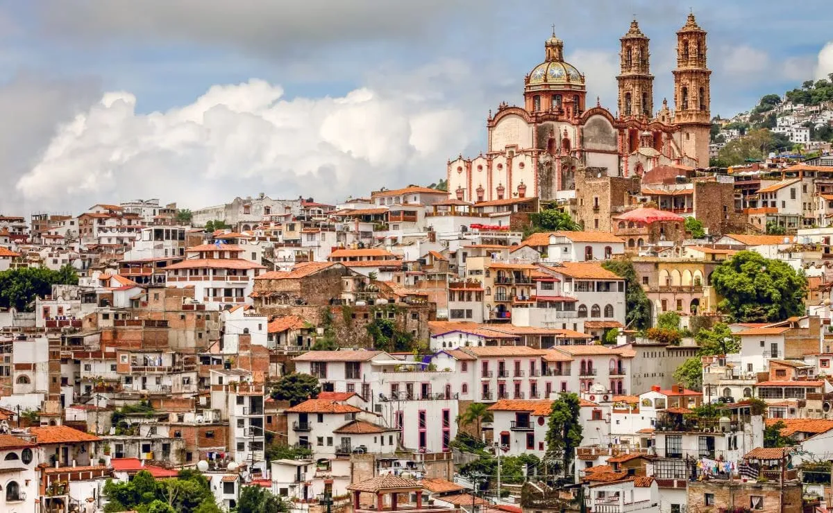 Panoramic view of Taxco de Alarcón with white colonial buildings, Santa Prisca Cathedral twin towers and silver workshops on the hillside