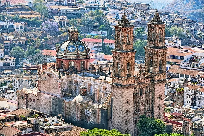 Winding cobblestone street in historic Taxco Guerrero Mexico with colonial architecture and silver shops