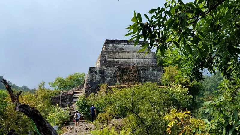 Shaded colonial courtyard in Tepoztlán with dark clouds gathering over the mountains