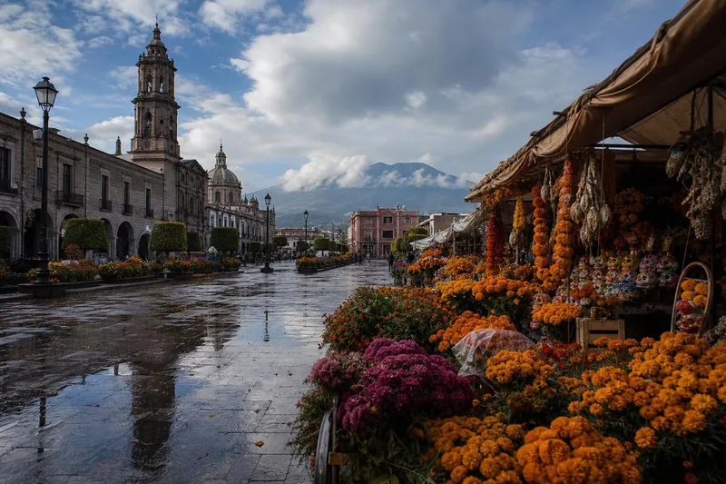Toluca plaza in October with marigolds, wet stone streets, and cool highland skies