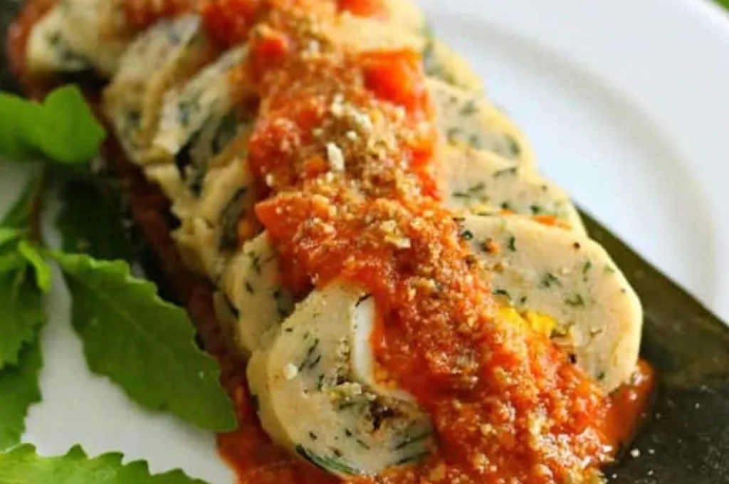 Sliced brazo de reina tamale with chaya and egg