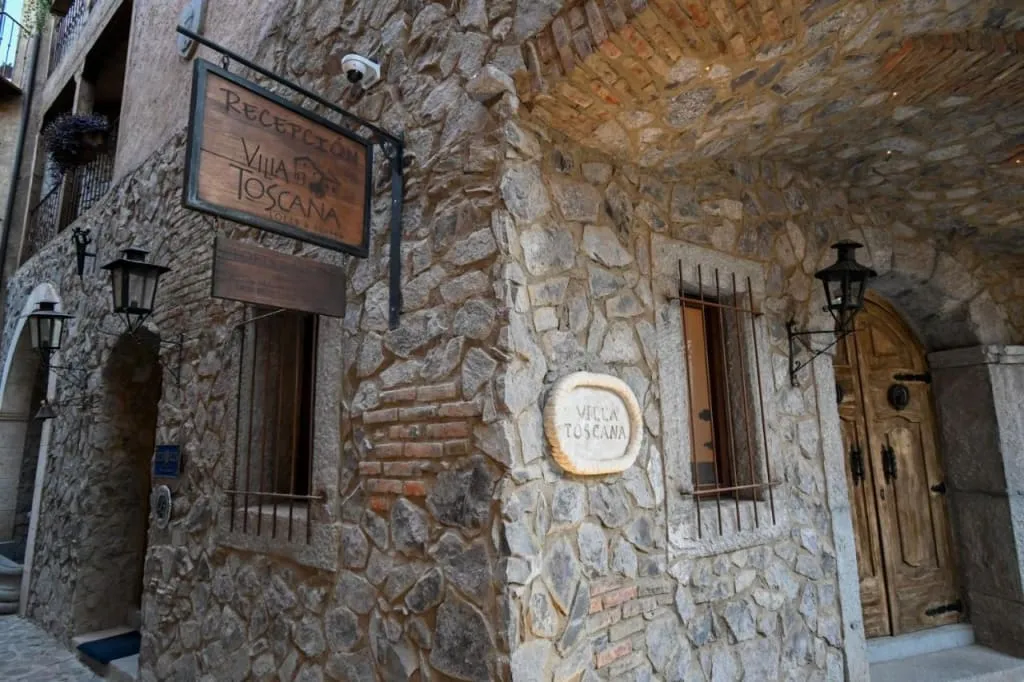 Hotel Toscana building with stone arches in Val'Quirico during an August weekend