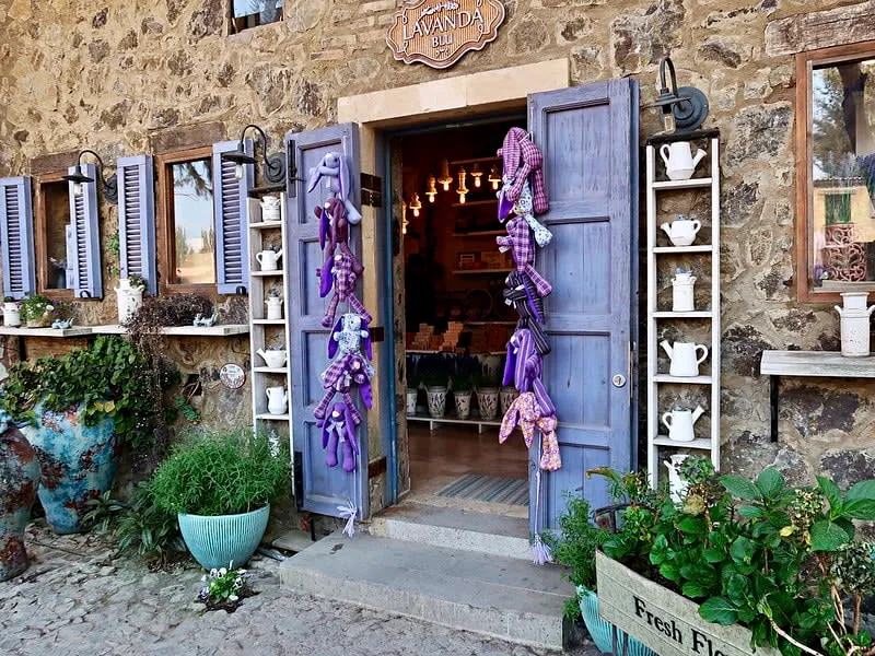 Val'Quirico shopfronts and stone walkways during an August rainy-season afternoon