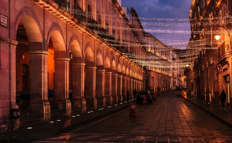 Pink-stone Zacatecas streets and green highland hills during the rainy season