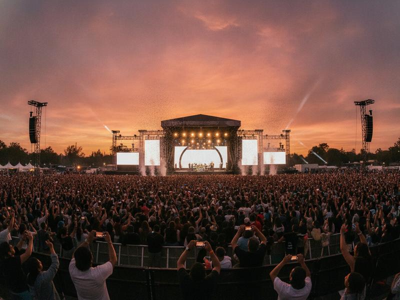 Large outdoor music festival stage and crowd at sunset in Mexico City