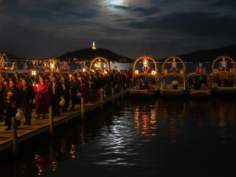 Travelers walking toward buses and boats in Pátzcuaro during Day of the Dead