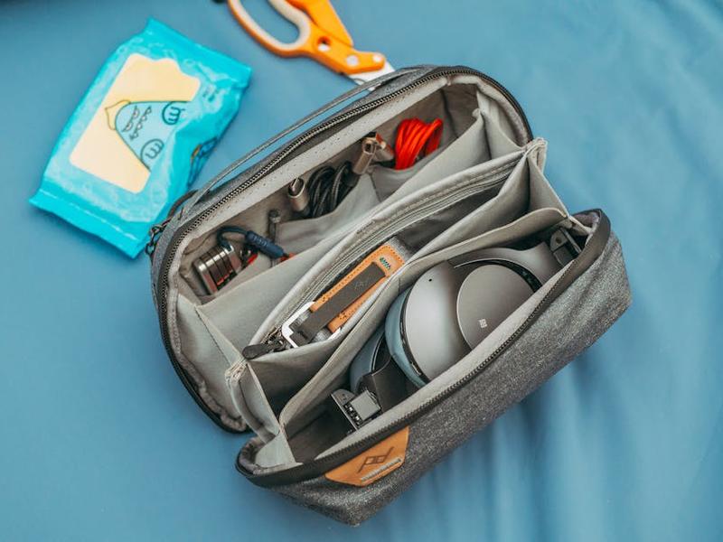 Flat lay of travel essentials including water shoes, dry bag, and pesos for Huasteca trip