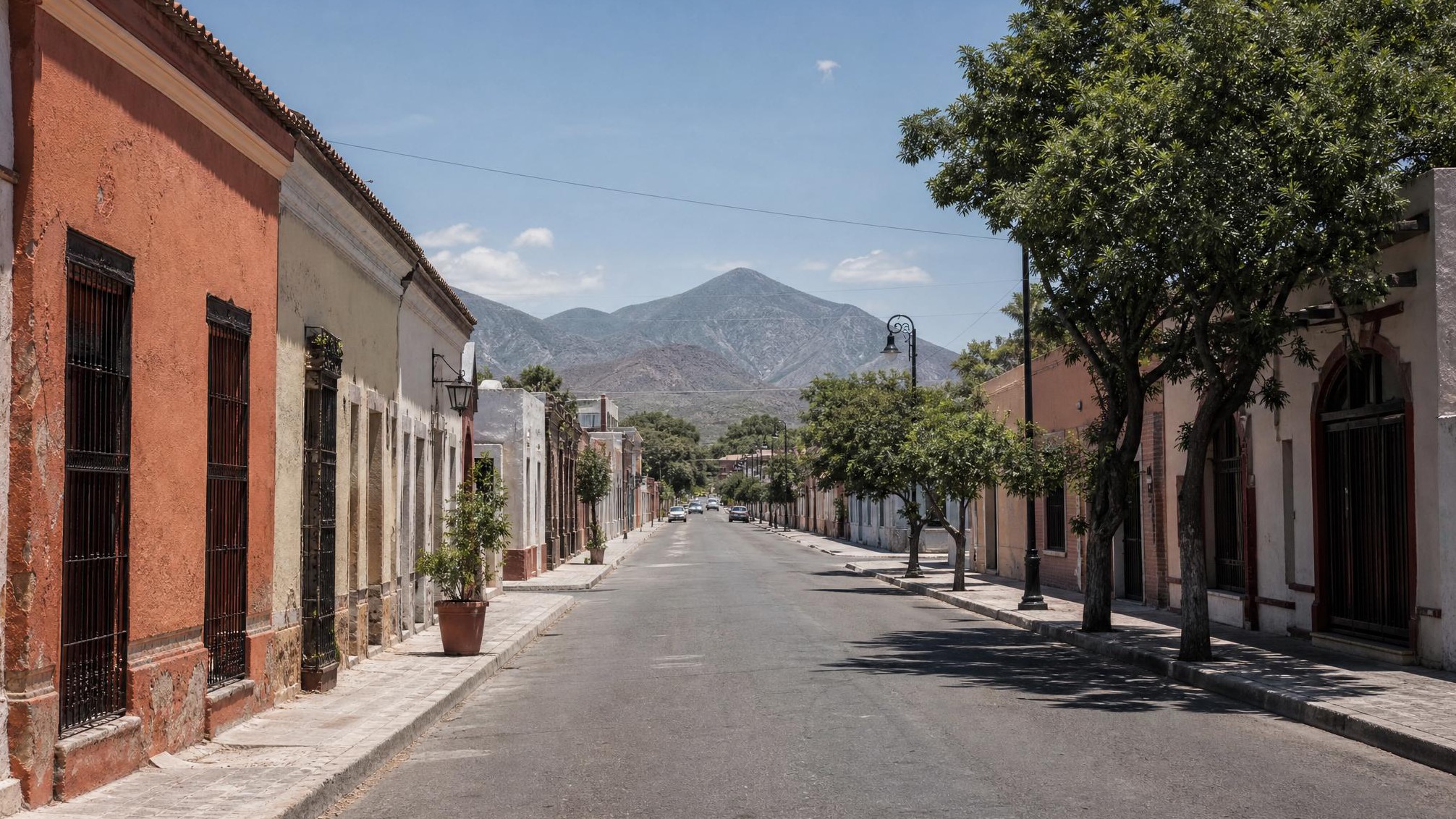 Bright July street near Linares historic center with Sierra Madre foothills beyond Nuevo Leon rooftops