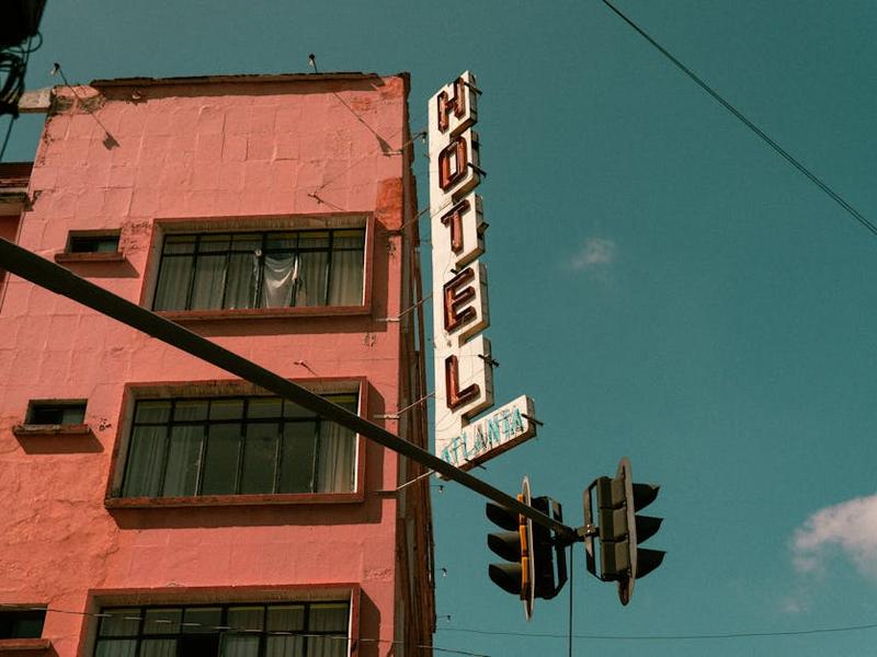 Central Saltillo hotel block with evening restaurant lights and street parking nearby